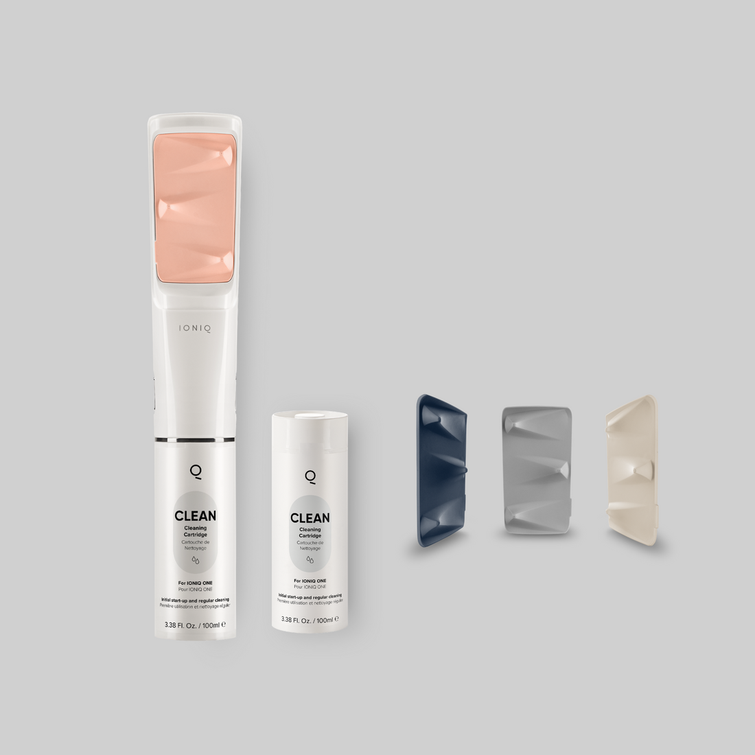 Auf dem Bild sieht man den IONIQ ONE Sprayer mit der CLEAN Kartusche, einer weiteren CLEAN Kartusche und Spraypads in 3 Farben.