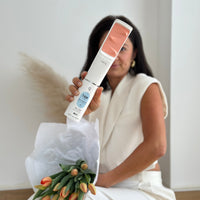 Eine Frau hält den IONIQ ONE Sprayer vor sich mit der TAN Kartusche und hat einen Blumenstrauß in ihrer Hand.